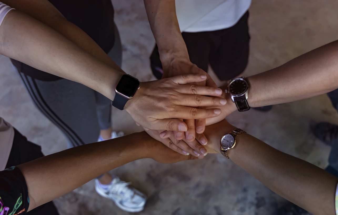 Team hands together symbolising partnership and collaboration